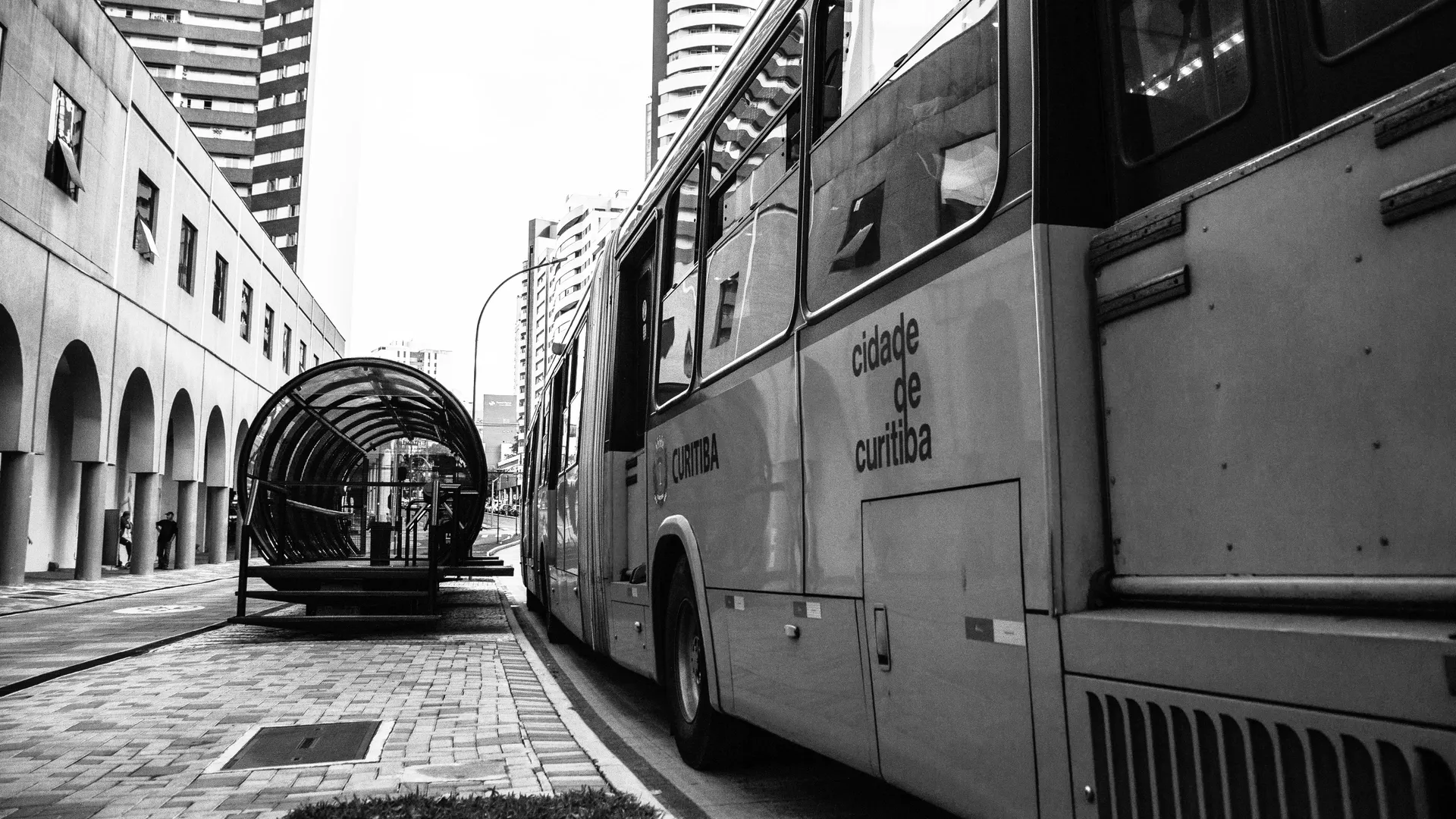 A Curitiba city bus alongside an estação-tubo, the iconic tube-station of the city's BRT network